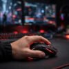 Ergonomic RGB gaming mouse in hand on gaming desk