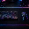 RGB backlit gaming mouse on mousepad next to keyboard